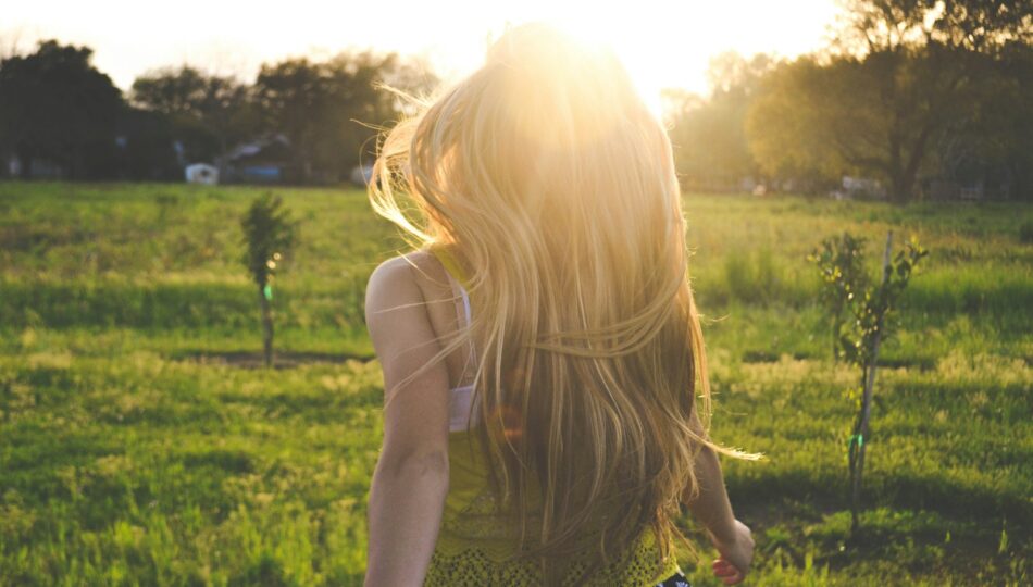 woman walking on lawn with trees