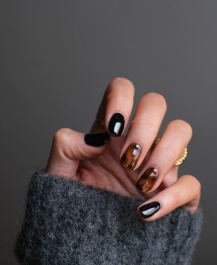 person wearing gold ring holding black textile